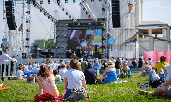 People sitting on grass watching outdoor event