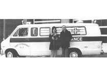 A pair of people posing in front of an ambulance in 1972