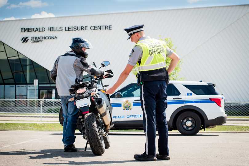Close up of a Community Peace Officer using a decibel reader to measure the noise coming out of the motorcycle