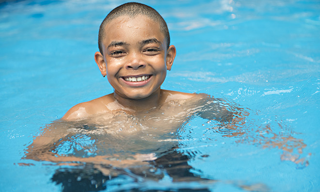 young child with a big smile while in a pool