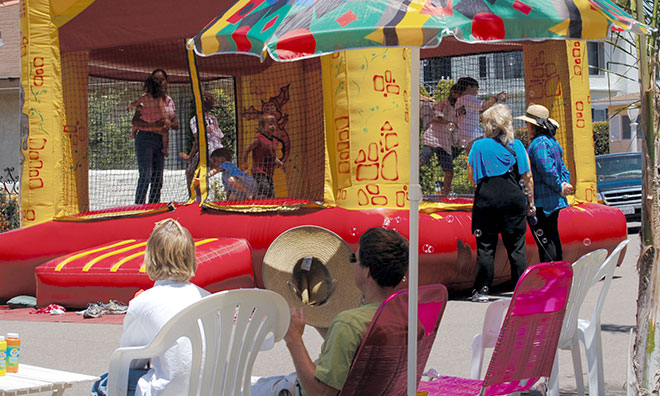 Image of neighbours having a party on their street with a bouncy castle