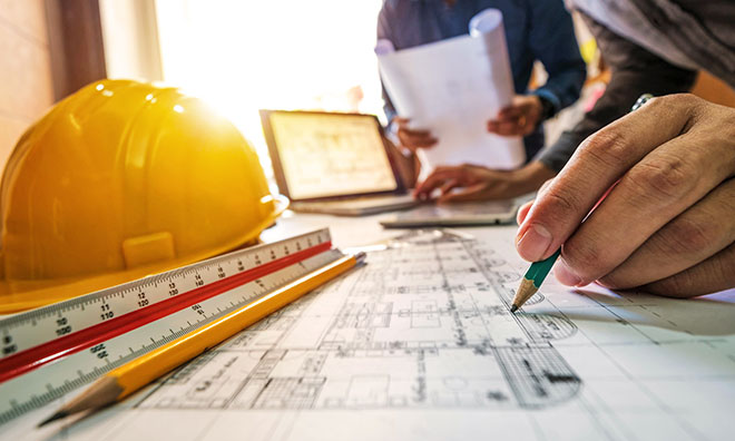 Hardhat and construction plans on desk